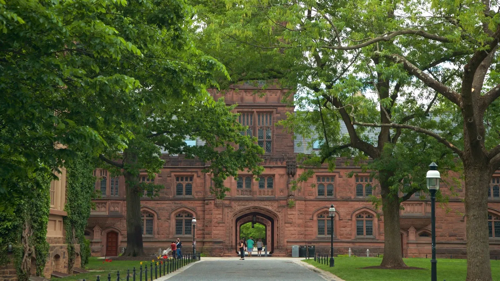 A red sandstone hall at Princeton University, seen through trees